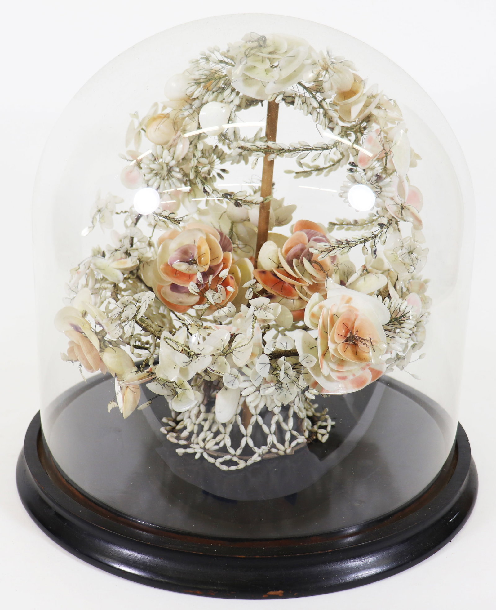 VICTORIAN SHELL WORK FLORAL BOUQUET UNDER DOME: A Victorian hand made shellwork centerpiece under a glass dome on a wood stand. Hours of work went into hand making this shell bouquet. Measures 13 x 13.5" x 13.5".