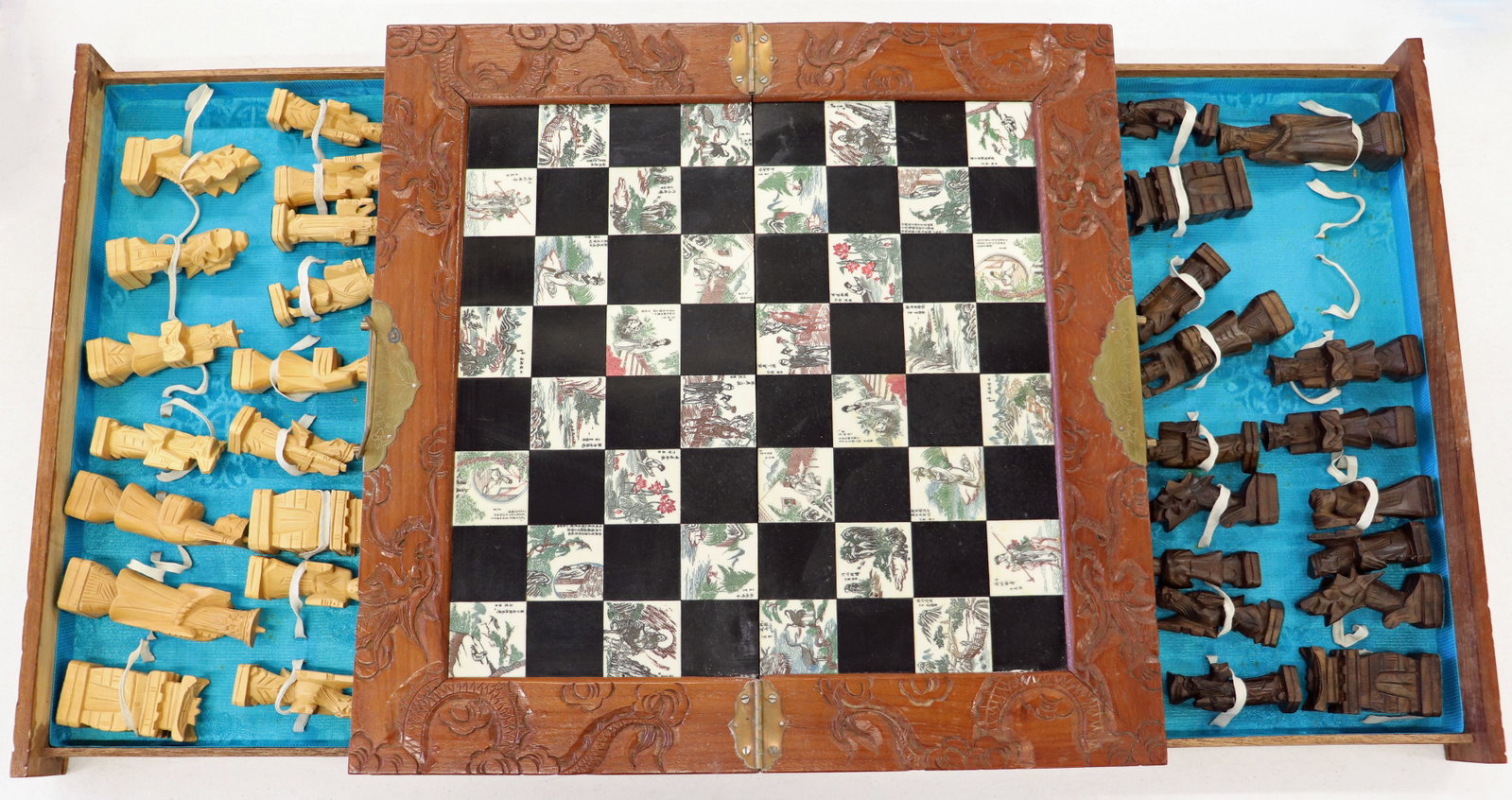 VINTAGE CARVED WOOD ASIAN CHESS SET: Vintage Chinese chess set with carved wood chess pieces. The board folds into a case for easy transport / storage, Exterior box hand carved with floral and dragon design. Missing one metal handle. Whe