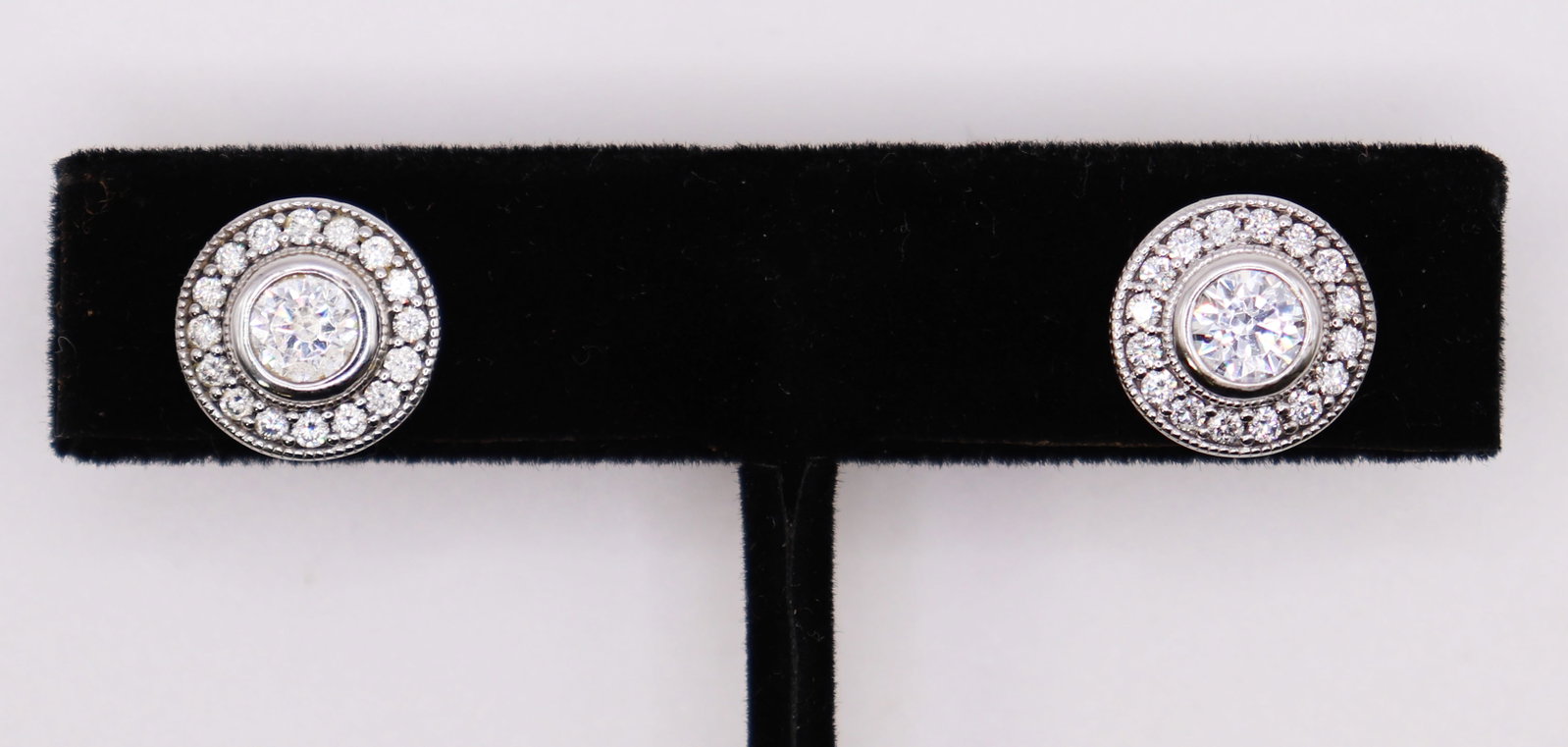 14K WHITE GOLD HALO STYLE EARRINGS: 14KT white gold earrings with larger center cubic zirconia stone surrounded with smaller accents. Total weight 5.1 grams (3.2 DWT). Earrings each approximately 1/2".