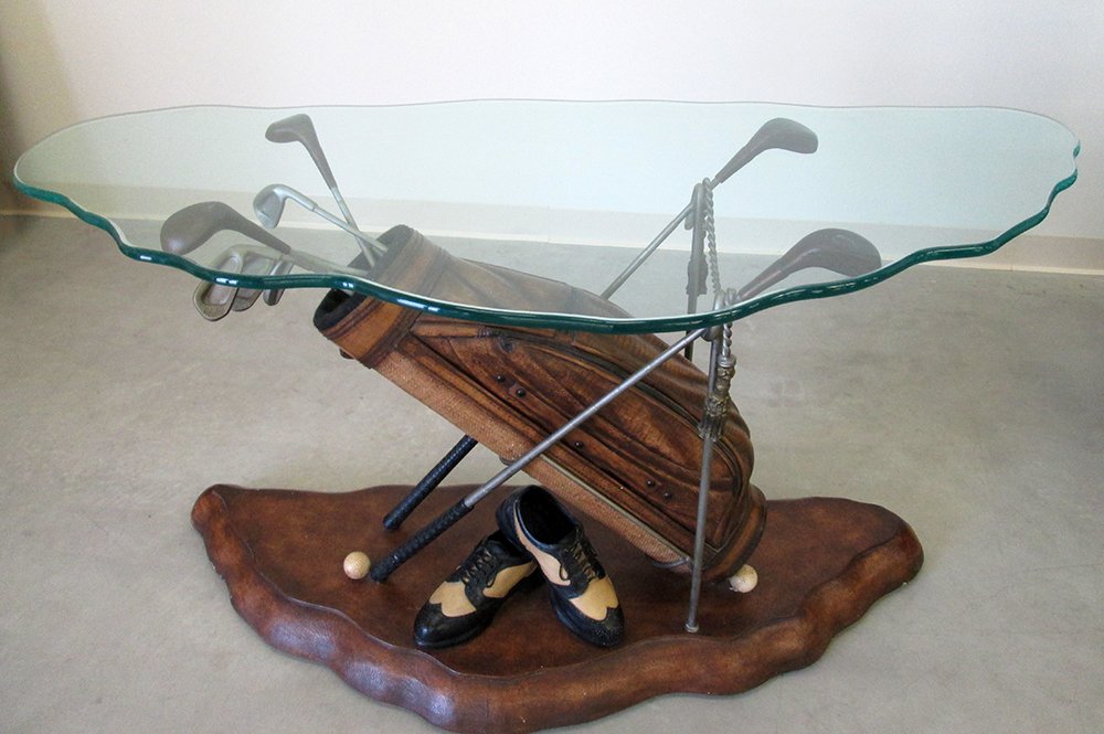 PGA TOUR CONSOLE TABLE: Limited Edition PGA Tour by Hooker Furniture console table. Table Features golf shoes, golf balls, and golf bag with golf clubs supporting glass top. 29 1/2" Tall 59" x 24" wide.