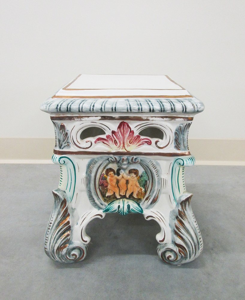 CAPODIMONTE STOOL: Four legged stool with cherub design. Measures 14" tall 11" x 11" wide.