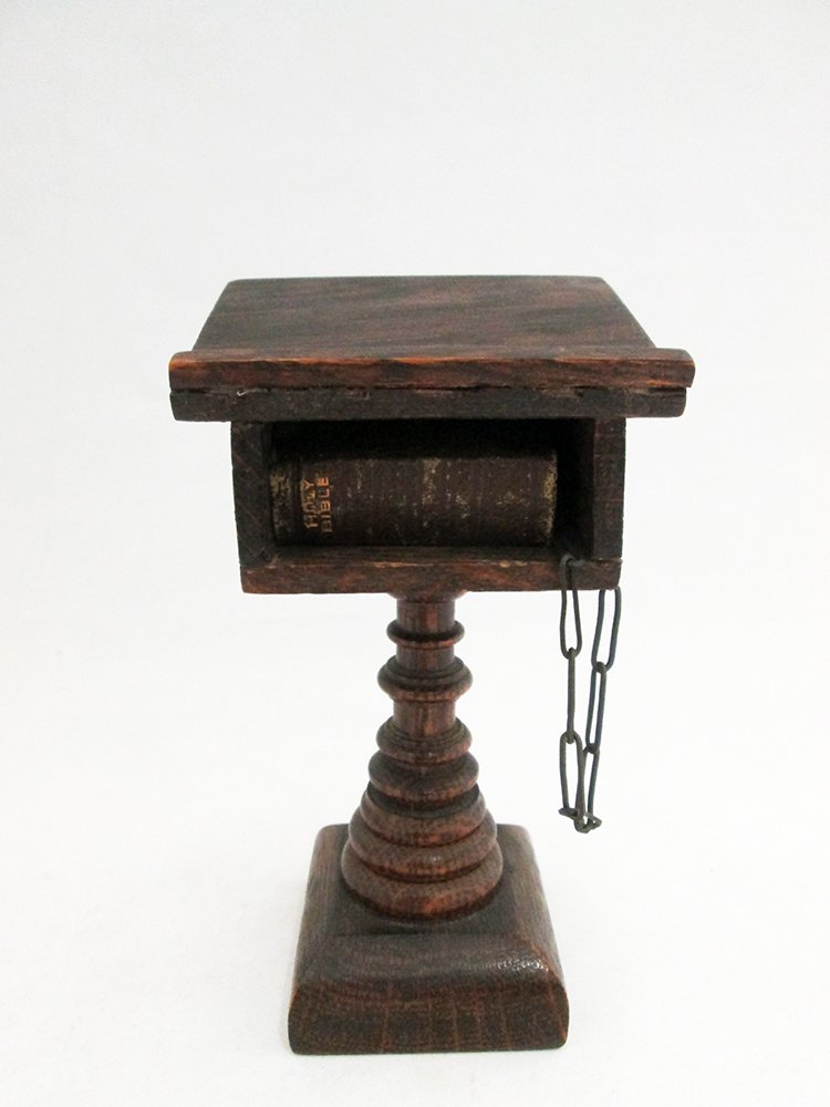 ANTIQUE MINIATURE CHAINED BIBLE & LECTERN: Miniature bible chained to a wood lectern. Lectern measures 6" tall. Bottom has label. Includes a block stamp. Provenance: Robert Lloyd Henderson Collection