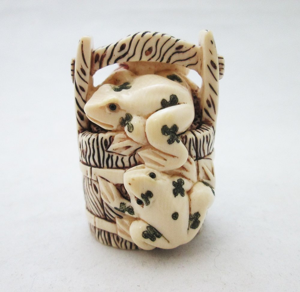 IVORY FROG NETSUKE: Two frogs on a well. Signed on back. 1 5/8" tall. THIS ITEM CANNOT BE SHIPPED OUT OF THE COUNTRY. PLEASE DO NOT BID IF SHIPPING RESTRICTIONS APPLY.