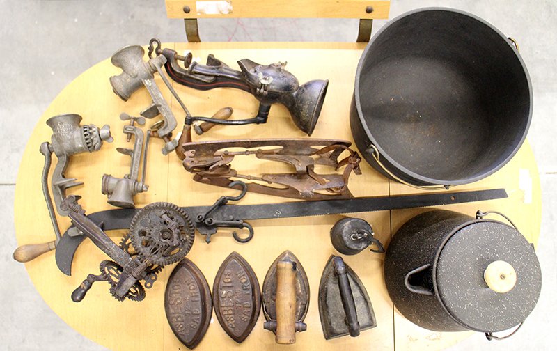 ANTIQUE CAST IRON PRIMITIVES & MORE: Enterprise hand crank coffee grinder, ice skates, hay scale, abestos sad irons, kettle, sinclair apple peeler, enamel coffee pot, & more.