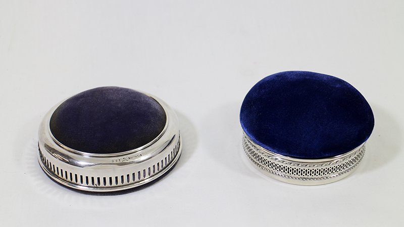 (2) PIN CUSIONS W/ STERLING: Two pin cushions with sterling silver. One made by Gorham with removable lid. Both marked sterling. 4" and 3 3/4" wide.