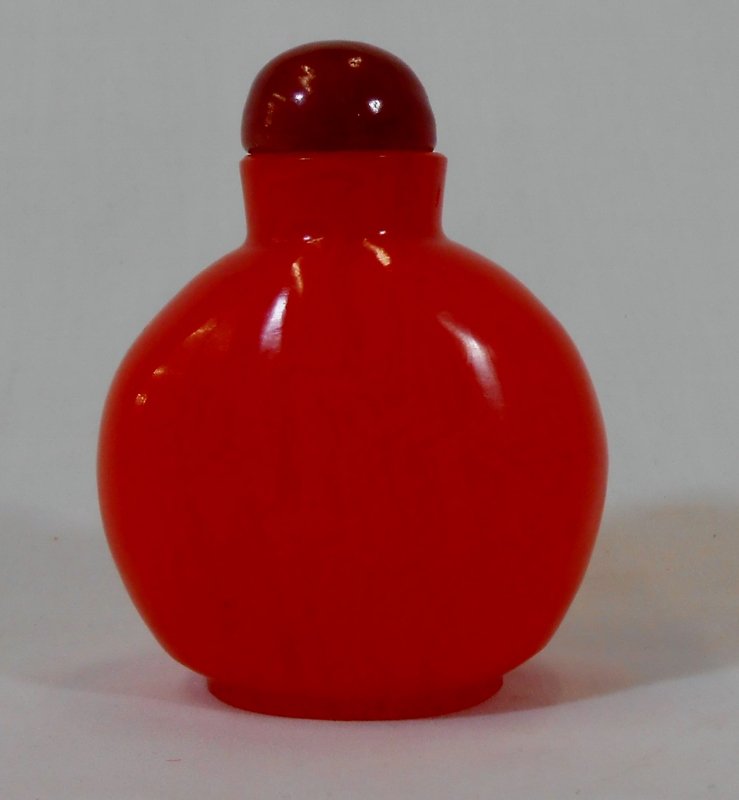 CHINESE RED CORAL SNUFF BOTTLE: Believed to be a 19th century red coral snuff bottle. When held to the light as shown in the pictures, you can see the varying degree of wavy lines in the glass. Measures 3" tall.