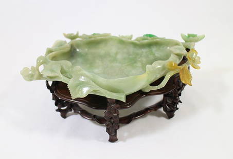 CHINESE GREEN JADE LOTUS BOWL: Chinese carved jade lotus lily bowl or brush washer, light green with dark green and orange color accents. Rim has stunning flower, leaf, and insect carvings. Bowl without stand approximately 10 1/2"