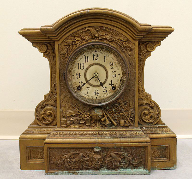 N. MUELLER SETH THOMAS CLOCK: N. Mueller gilded iron metal clock case with Seth Thomas clock. Clock is very ornate with, eagle, tools, globe, & other various decorations. Includes pendulum. Some missing and unoriginal screws. 14 1