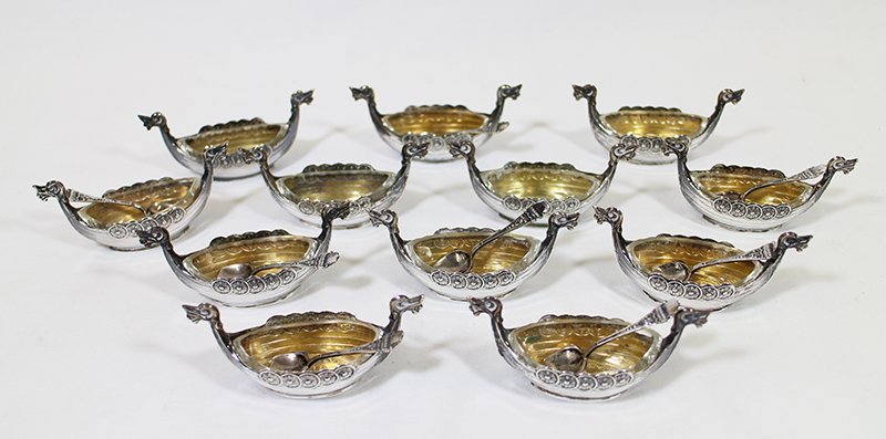 (12) SILVER VIKING SHIP SALT CELLARS: Set of 12 Norwegian viking ship salt cellars. Each salt cellar has glass insert. 9 matching spoons with viking ships marked 830 S. Ships are marked Norge.