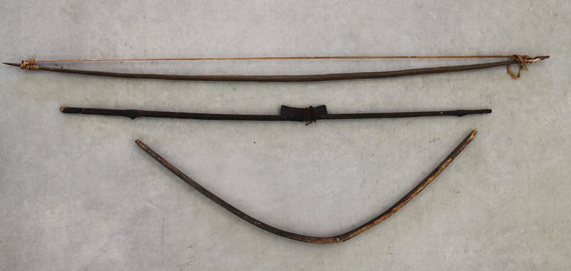 BOW DRILL & HUNTING BOWS: Bow drill made from a wagon wheel, primitive bow made from old barrel, and hunting bow.
