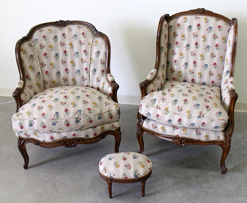 (2) UPHOLSTERED ARMCHAIRS: Two upholstered armchairs and footstool. Each chair with carved wood flower accents.