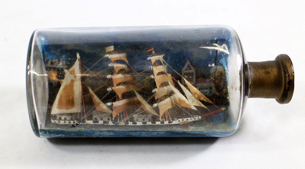 VINTAGE SHIP IN A BOTTLE: Wooden ship in glass blown bottle. 7" long. Date on building c1930's.