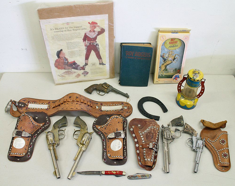 ROY ROGERS CAP GUNS HOLSTERS & MORE: Collection of vintage Roy Rogers cap guns with holsters, lantern, horseshoe, pocketknife, book and more. Some wear and losses. One gun broke in two pieces.