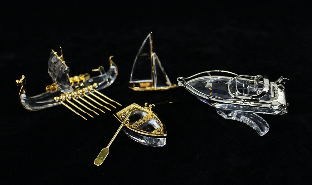 SWAROVSKI CRYSTAL BOAT COLLECTION: Four Swarovski Crystal boats - Viking ship, speed boat, sailboat, and row boat.