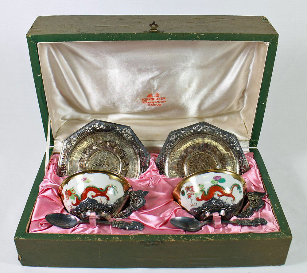CHINESE PORCELAIN & SILVER TEACUP SET: Chinese porcelain tea cup set with mounted silver dragon handles, saucers, and figural spoons. In presentation box. Silver unmarked.