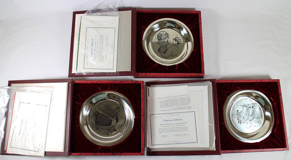 (3) STERLING FRANKLIN MINT NORMAN ROCKWELL PLATES: Three sterling silver Franklin Mint Normal Rockwell plates including Trimming the Tree, Hanging the Wreath, and Home for Christmas. Each with book style case.