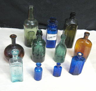 Early Bottles: Group of 11 bottles, as listed below. 11 inch or smaller, varying types and colors; moderate wear, no chips. Free-blown amber chestnut with ribs * A. M. Bininger & Co olive gin * D. Sears 3-piece mold