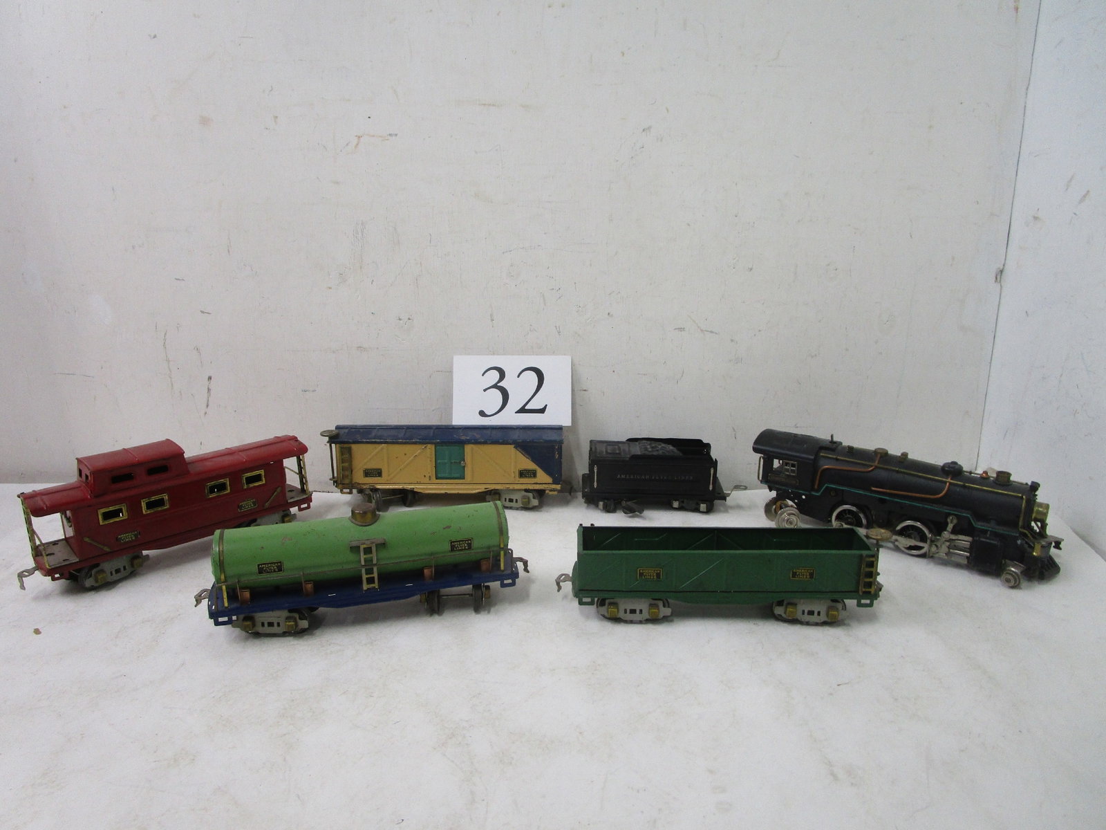 American Flyer Train: Black American Flyer engine, green tank car, & open car, tender, cream boxcar, red caboose