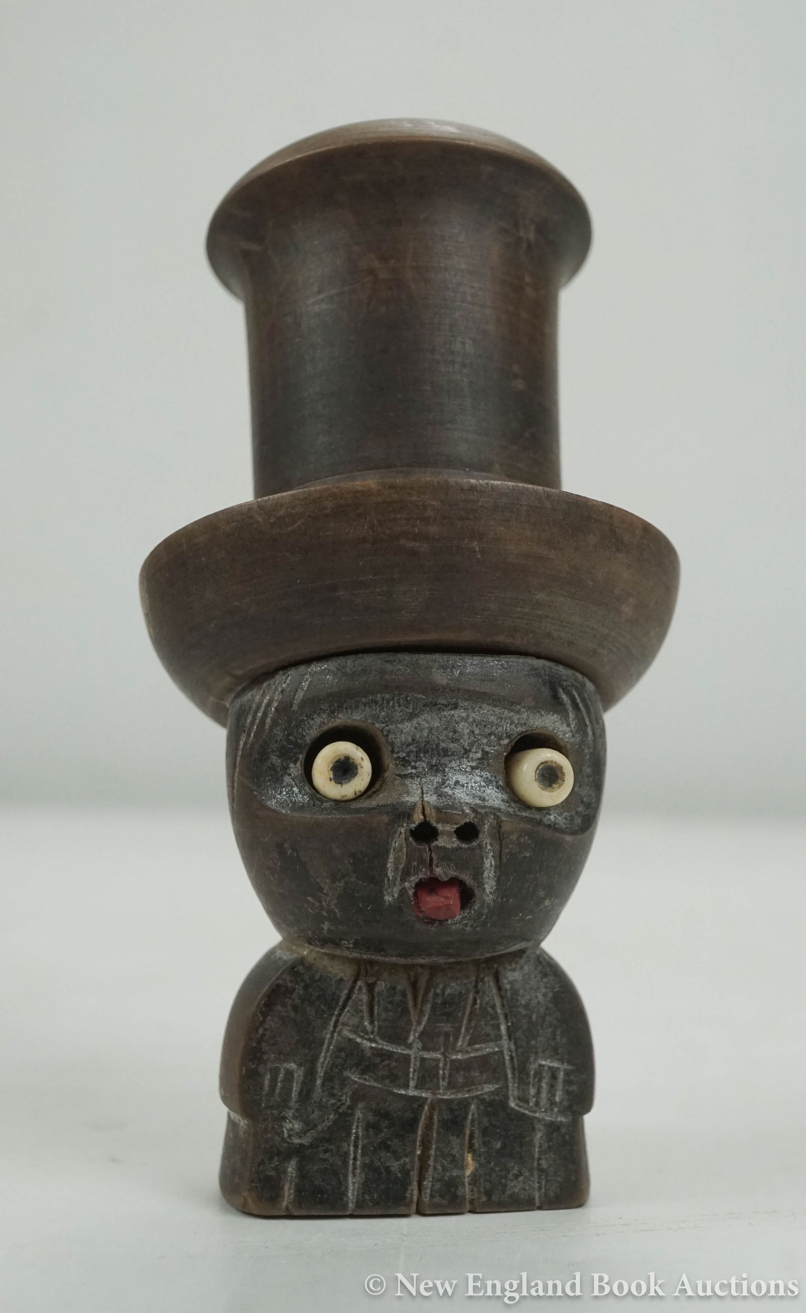Dice Shaker: 10. Dice Shaker. Carved wooden dice shaker with inset eyes and tongue, contemporary black & white dice inside screw-off hat; moderate wear. Np, Circa 1900 [75/100]