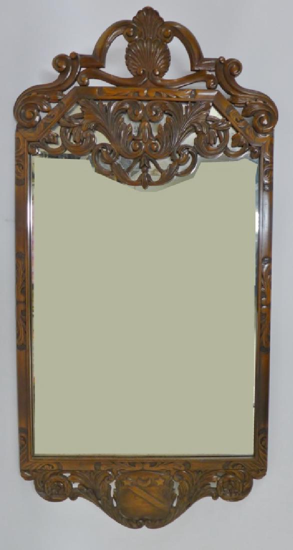 Kittinger Carved Walnut Mirror: Ornately carved wood framed mirror by Kittinger. Imperfections. Label & Makers Mark on back. Height: 49 3/4"; Width: 24 1/2". STERLING ASSOCIATES STRIVES TO PROVIDE ACCURATE, OBJECTIVE, & FAIR INFORMA