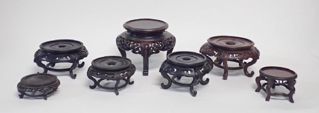 Vintage Carved Hardwood Footed Chinese Stands: Intricately carved pierced wood designs, footed. Includes 7 circular displays / stands. Imperfections. (Rosewood, Asian, Orientalist, Antique) Height: 6 1/8"; Diameter: 7 5/8". STERLING ASSOCIATES STR