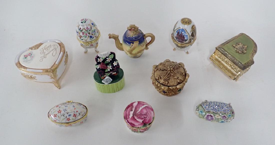 Collection of Decorative Boxes: Ten assorted boxes. Includes: two egg & one oval porcelain boxes with gilt accents, two music boxes (one marked Japan), Hand Painted Nini Dragon Teapot, Crystal "purse", other makers marks include: ME