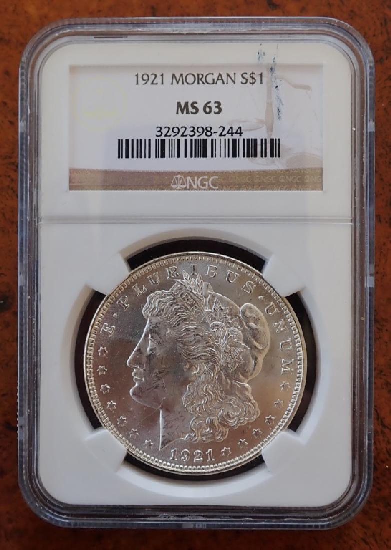 1921 Morgan Silver Dollar: Graded 1921 Morgan silver dollar coin. NGC graded at MS 63. Cased. ($1, money, collecting, Numismatics, currency, eagle, E Pluribus Unum) STERLING ASSOCIATES STRIVES TO PROVIDE ACCURATE, OBJECTIVE, &