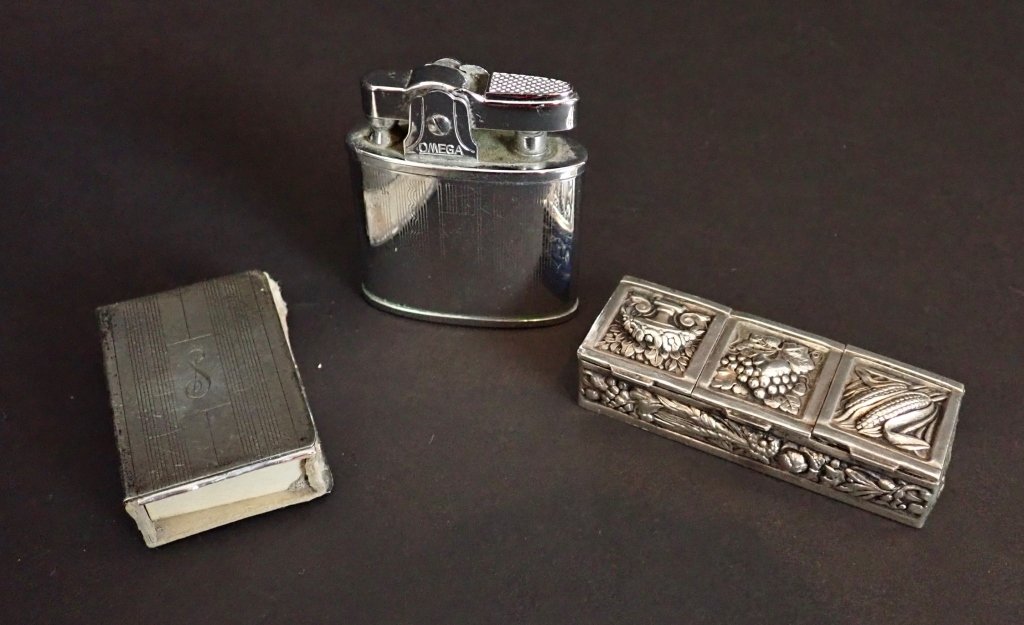 Silver & Silver Plate Table Top Accessories: Collection of three small silver or plate accessories includes:Monogrammed sterling silver matchbook holder, marked sterling;Silver plate three compartment pill box; and an omega table lighter, marked