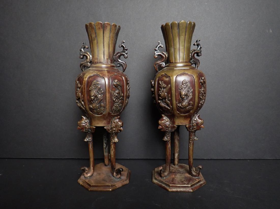Pair of Japanese Patinated Bronze Ovoid Vases: Lot includes: Pair of Bronze Ornate Japanese Ovoid Vases / Censers with Swooping Tripod Supports and Solid Octagonal Base, Bird and Flower Relief Panels. Imperfections: Age, Blemishes, Wear. Dimension