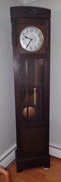 German Longcase Grandfather Clock: Dark carved wood grandfather clock. Long case turn of the century German grandfather clock. Includes pendulum & weights. Height: 83 1/2"; Width: 19; Depth: 9". (time, longcase clock, floor clock, tall