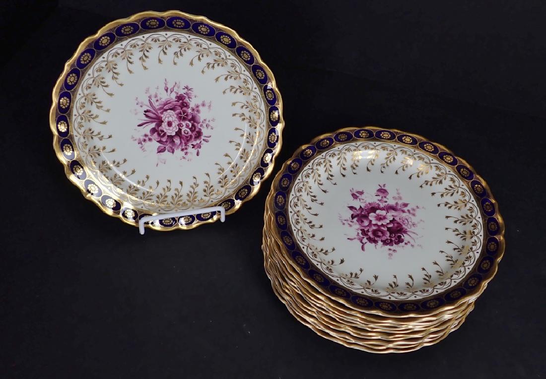Eleven Royal Worcester Gilt Plates: 11 Gilt plates feature purple center flowers. Makers marks on backs. Diameter: 8 7/8". Imperfections. STERLING ASSOCIATES STRIVES TO PROVIDE ACCURATE, OBJECTIVE, & FAIR INFORMATION ON ALL LOTS. WE WIL