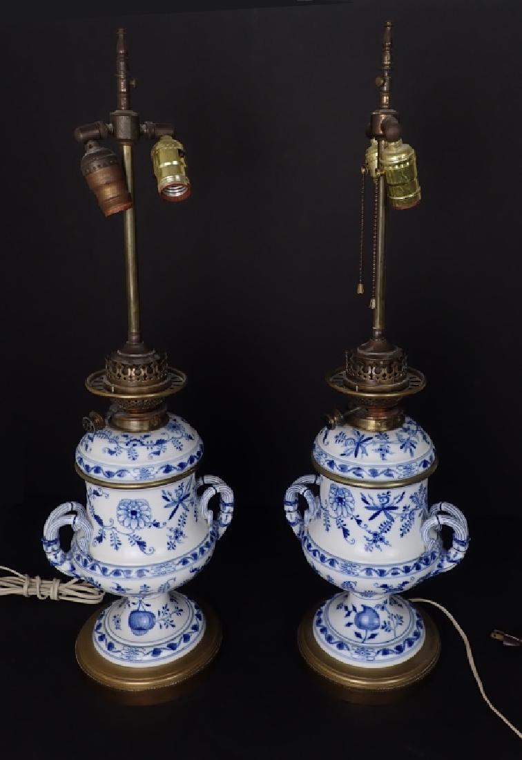 Pair of Meissen Blue and White Porcelain Lamps: 19th Century Meissen Blue Onion Converted Oil / Kerosene Lamps. Pair of table lamps feature floral design and handled sides. Converted brass fixture marked: W. Whiteley Westbourne Grove London. Knob r