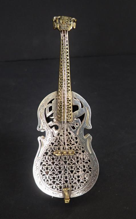 Sterling Silver Netafim Israeli Spice Box: Gilt & Sterling Silver Spice Box. In the shape of a guitar, cello or violin. Pierced scrolling design. It has a collapsible attached stand to reverse side, and a small hinged door at bottom edge. A ma