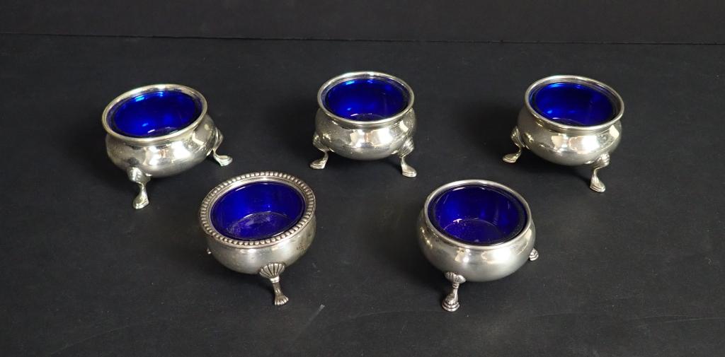 Sterling Silver Salt Cellars with Cobalt Glass: Five Cobalt Blue glass inserts each sit in a sterling silver, footed salt cellar. 3 are marked "Sterling 9X" and bear a hallmark. 1 is marked "Empire Sterling". 1 is marked "Sterling". Approximate gro