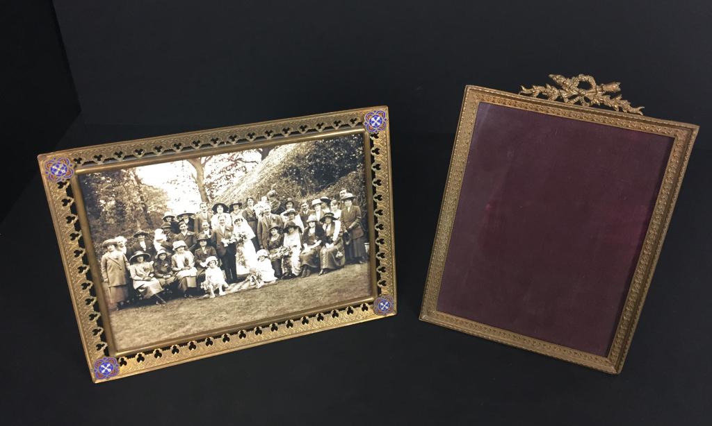 Two Antique Bronze Frames: 2 frames including one with enamel designs applied to the corners. Black & white photo included. Also includes bronze frame with bow detail along the top edge. Both have glass. Enamel detail frame Hei