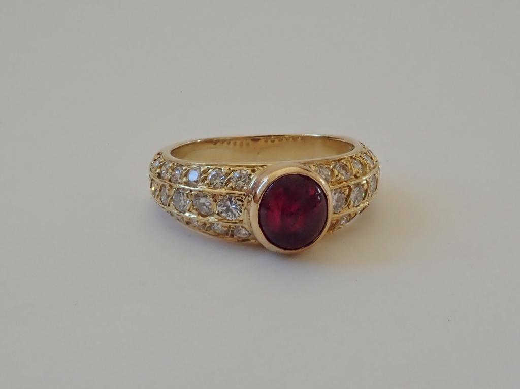 18K Yellow Gold, Diamond & Ruby Ring: Ring features center ruby with rows of diamonds partially encircling the 18k yellow gold band. 36 diamonds. Approximates: .75cts total; Color: G-H; Clarity: SI1 / VS2. Cabochon ruby approximately 6 1/