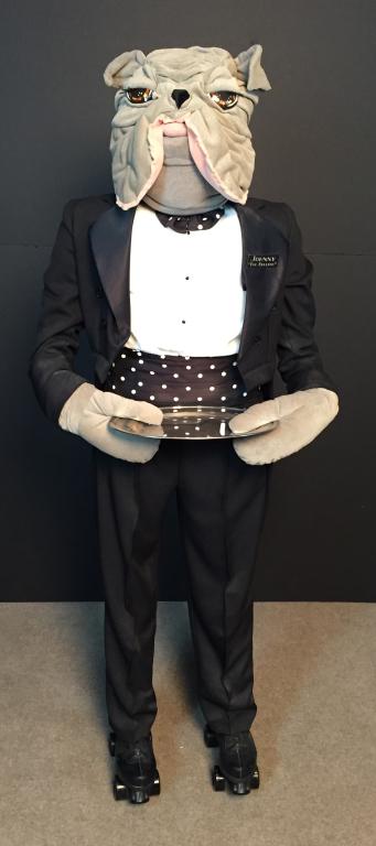 Johnny the Bulldog Butler, Life Size Statue: Human-size stuffed butler statue in tuxedo w/bulldog head, on roller skates, w/serving tray. Height: 66"; Width: 21"; Depth: 17". Imperfections. STERLING ASSOCIATES STRIVES TO PROVIDE ACCURATE, OBJECT
