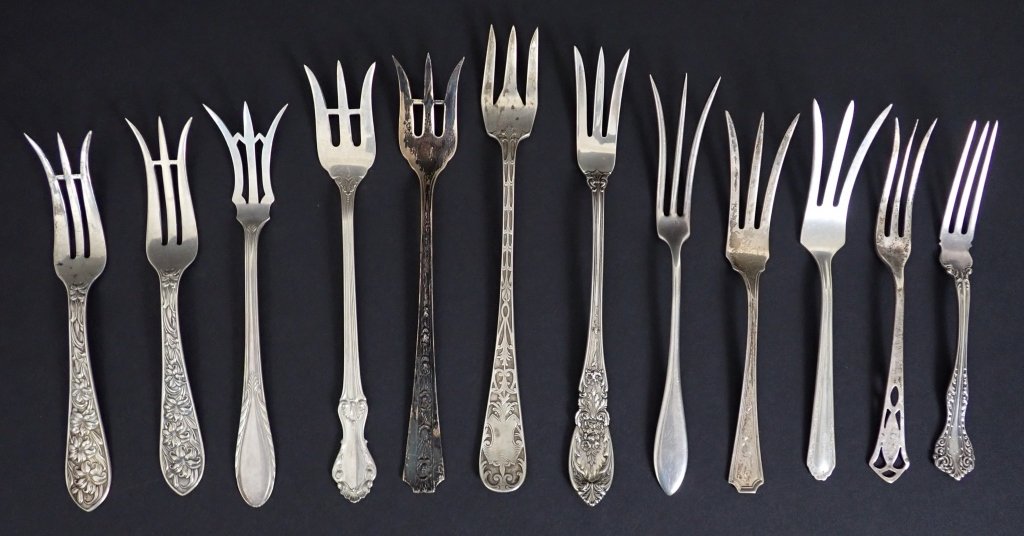 Sterling Silver Cocktail / Lemon Fork Assortment: 12 assorted small sterling silver serving forks. Lemon Fork, strawberry, seafood, oyster. Various patterns and sizes. Makers marks include: Frank Whiting, National Silver Co, International Silver and 