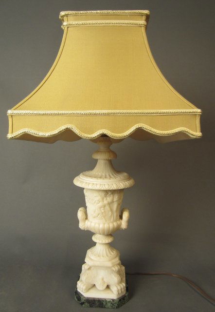 Ornate White Alabaster Urn as Lamp with Shade: Ornate white alabaster urn as lamp with figural and floral relief carvings. Lamp rests on claw feet and octagonal green marble base. 19th Century Height: 27", Width: 6"