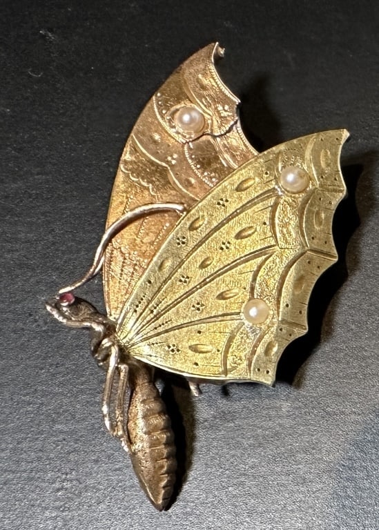 14K Gold And Pearl Butterfly Locket: Two tone 14k gold locket in the form of a butterfly with pearls on wings and a ruby eye and a glass hinged window on reverse. 7.7g 50mm x 28mm STERLING ASSOCIATES STRIVES TO PROVIDE ACCURATE, OBJECTIV