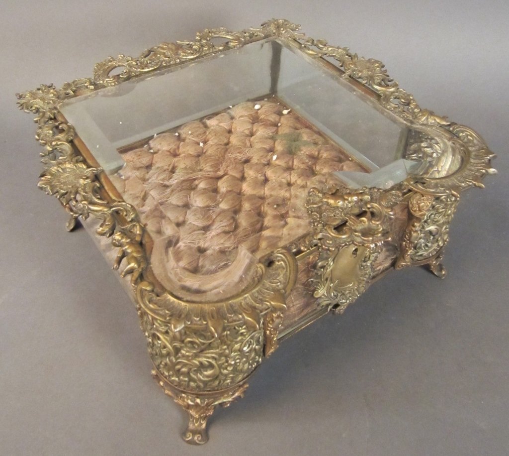 Ornate Beveled Glass & Brass Jewel Box, 19th C: Hinged beveled glass and brass jewel box with ornate figural design. 19th Century Dimensions of box: 11" x 11 3/4" x 5 3/4"