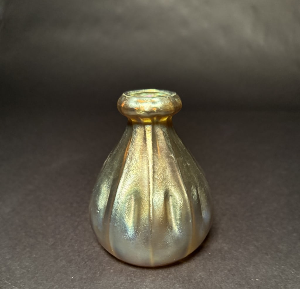Tiffany Gold Favrile Pinched Gourd Form Bud Vase: Louis Comfort Tiffany (American, 1848-1933), early 20th century. A Tiffany Studios iridescent gold favrile pinched gourd form bud vase with vertically ribbed body dimpled at center with flattened bulb