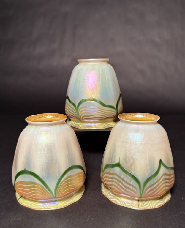 Set Of 3 Quezal Pulled Feather Shades: Three Quezal art glass lamp shades in the Pulled Feather pattern. Exemplary pieces presenting opal iridescent exteriors with encircling green, gold, and opalescent white Pulled Feather designs, and ri