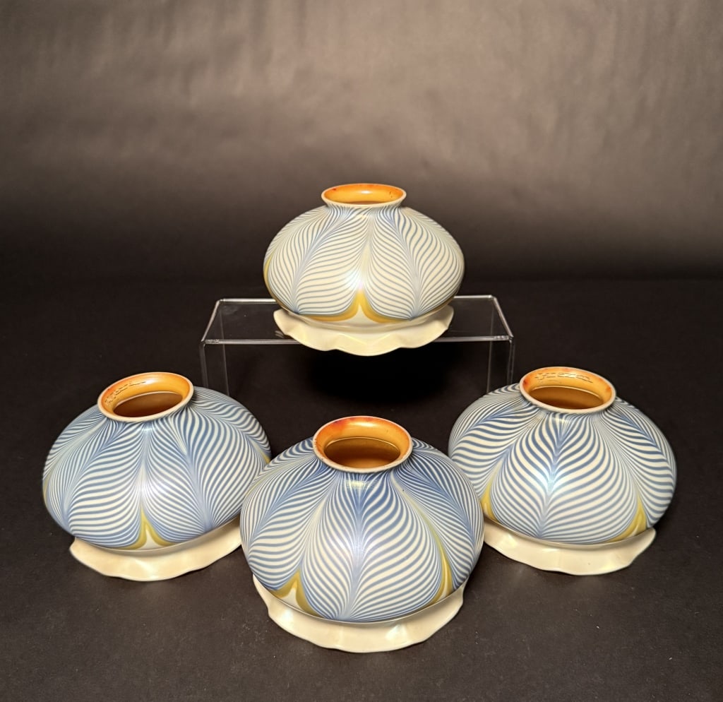 Set Of 4 Quezal Pulled Feather Shades: Set of four blue, white and gold aurene interior and scalloped bottoms. 3 3/4" H. 5" Bottom opening. 2 1/4" Fitter. The Estate of the late Judy Boyd, New Jersey.STERLING ASSOCIATES STRIVES TO PROVIDE 