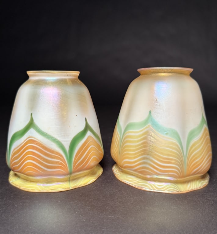Pair Of Quezal Iridescent Pulled Feather Shades: Set of two Quezal iridescent ghreen and gold pulled feather art glass shades. 4 1/2"H. 4" Bottom opening. 2 1/4" Fitter. The Estate of the late Judy Boyd, New Jersey.STERLING ASSOCIATES STRIVES TO PRO