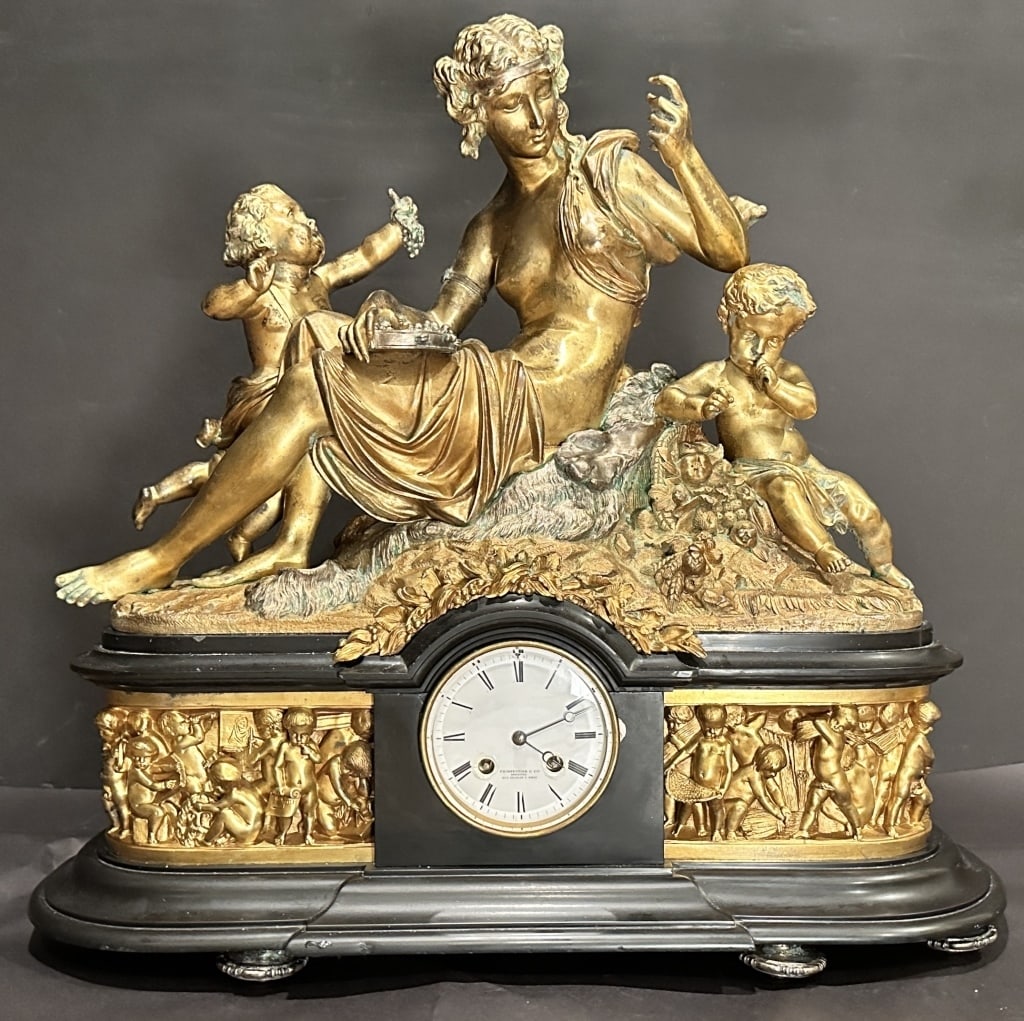 French 19th Century Figural Gilt Bronze Clock: Antique French 19th century gilt and silver over bronze and Belgian black marble clock. A Carrier-Belleuse model of a woman on a bear pelt with two putti, tambourine and grapes.Movement marked on face