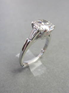 Engagement Ring: 2.74 carat diamond and platinum engagement ring. Diamond is GAI certified. Round brilliant cut has color grade: E. Clarity grade: SI2. Cut grade: good. Baguettes on either side of the center diamond.