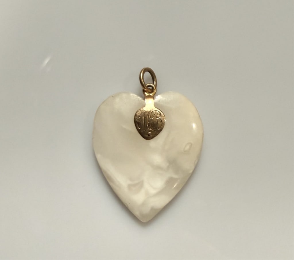 14K Gold And Stone Heart Form Pendant: Engraved. Approx. dimensions 1 1/4" x 1". Tested 14K. Approx. gross weight 9.0 grams. STERLING ASSOCIATES STRIVES TO PROVIDEACCURATE, OBJECTIVE, & FAIR INFORMATION ON ALL LOTS. WE WILL BE HAPPY TO ANS