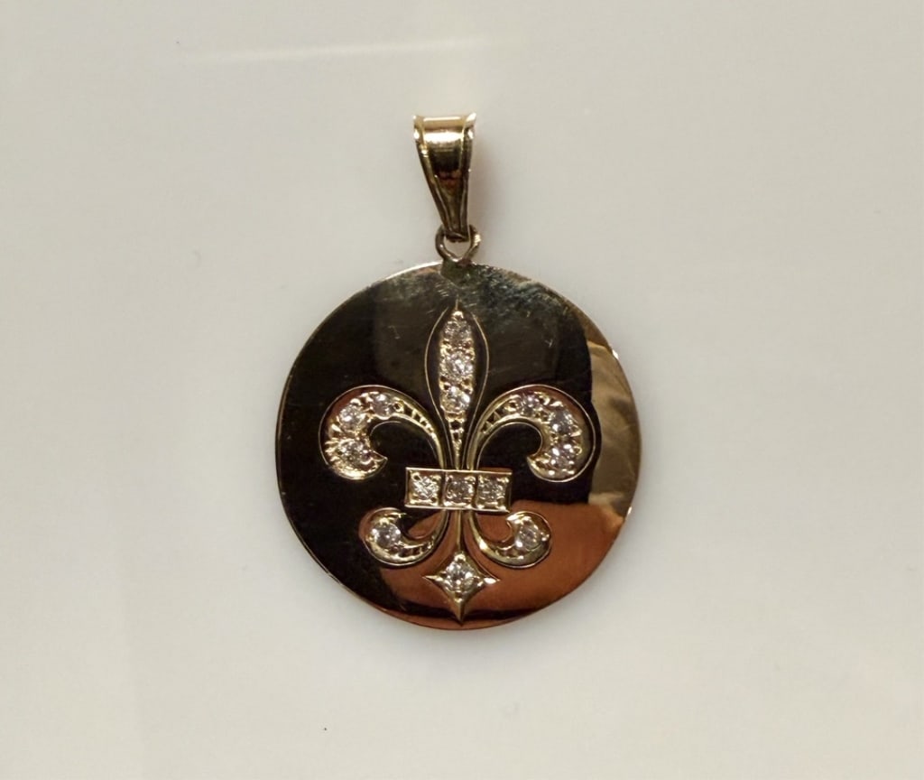 14K Gold And Diamond Fleur-De-Lis Pendant: Approx. dimensions 1 1/2" x 1" including bail. Marked 14K. Approx. gross weight 3.5 grams.STERLING ASSOCIATES STRIVES TO PROVIDE ACCURATE, OBJECTIVE, & FAIR INFORMATION ON ALL LOTS. WE WILL BE HAPPY T
