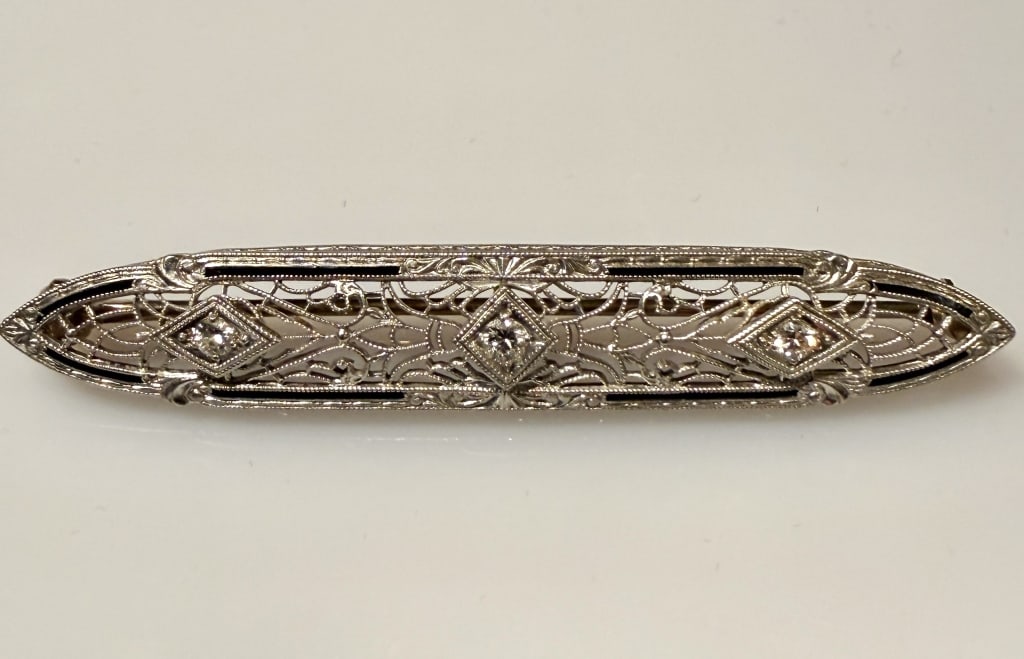 14K White Gold And Diamond Art Deco Brooch Pin: Approx. dimensions 2 1/4" x 1/2". Marked 14K. Approx. gross weight 4.7 grams. STERLING ASSOCIATES STRIVES TO PROVIDEACCURATE, OBJECTIVE, & FAIR INFORMATION ON ALL LOTS. WE WILL BE HAPPY TO ANSWER ANY